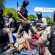 Police move detained demonstrators in the bed of a pick-up truck to a police station during a protest to demand the resignation of Haitian President Jovenel Moise in Port-au-Prince, Haiti, Sunday, Feb. 7, 2021.
